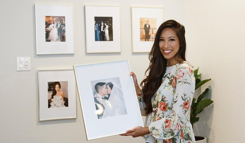 Influencer smiling and holding a Framed Photo Print of her kissing her husband on wedding day